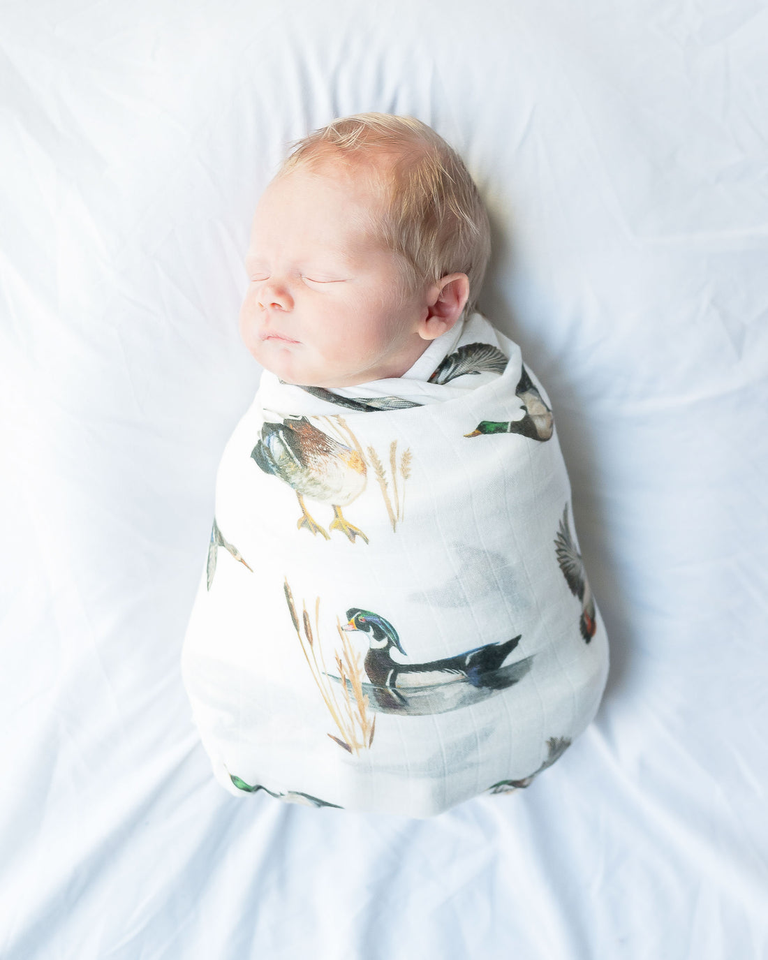 Vibrant watercolor pattern of diving ducks on a soft swaddle, perfect for wrapping newborns in style and comfort