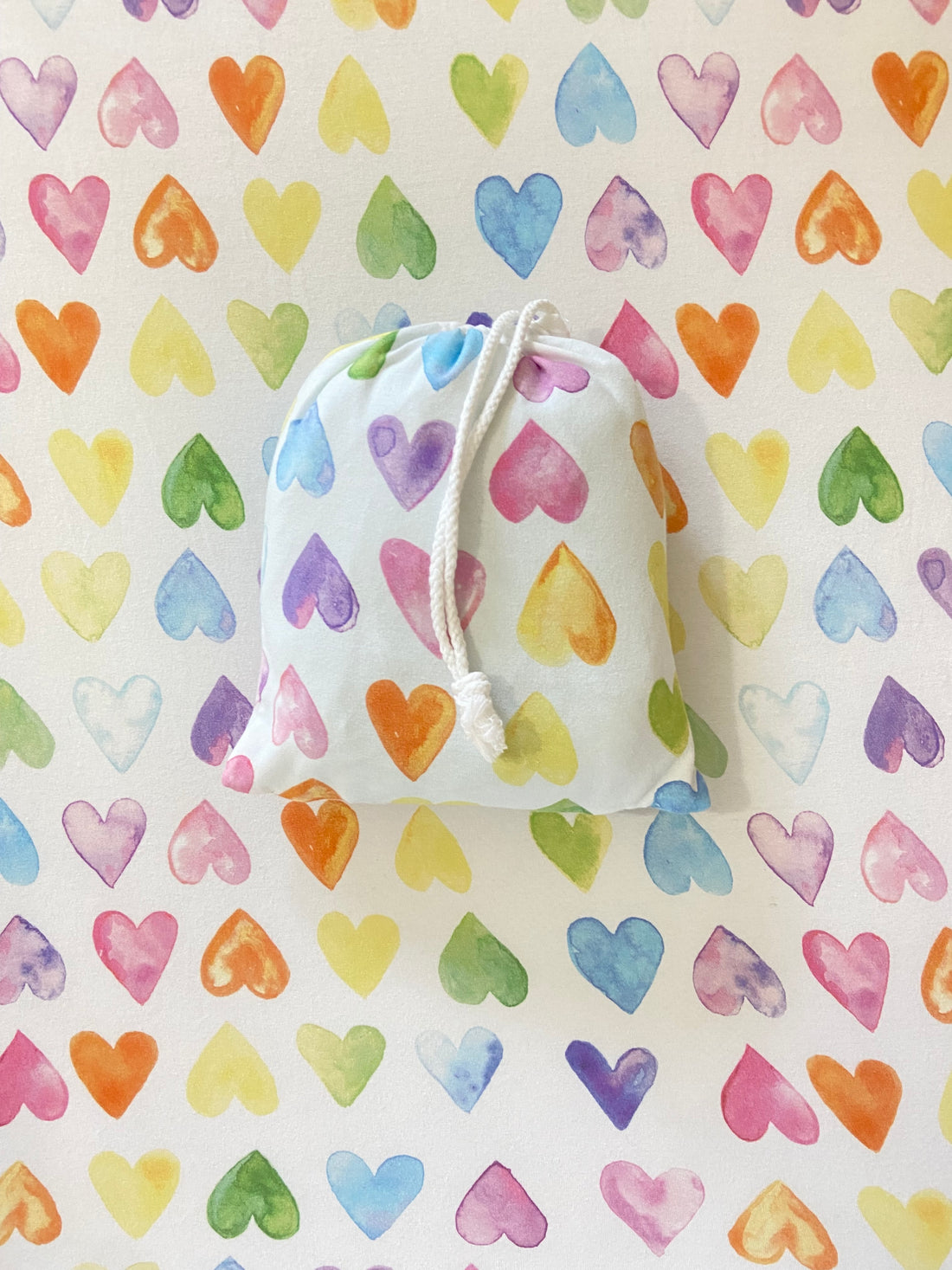 Fitted baby crib sheet in rainbow heart print, designed for a cozy and snug fit on baby or toddler beds