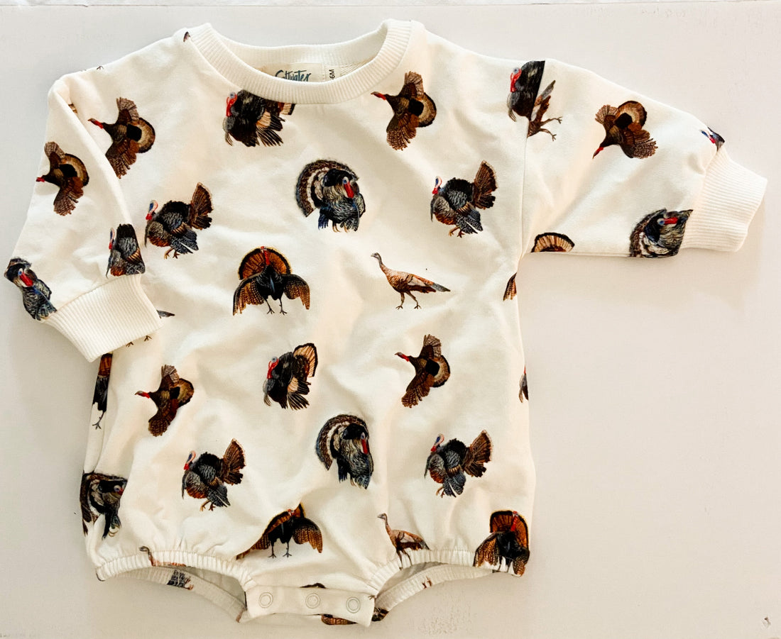 Snap closure detail of the Turkey Trot sweatshirt romper for easy diaper changes